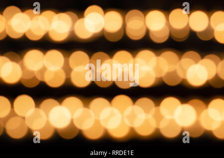 Viele schöne Kerzen in einer Reihe mit einem golden leuchtende gelbe LED - Nicht fokussiert Stockfoto