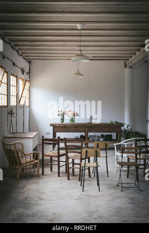 Licht grunge Zimmer mit Stühlen und Tisch mit sträuße von frischen Blumen in Vasen Stockfoto