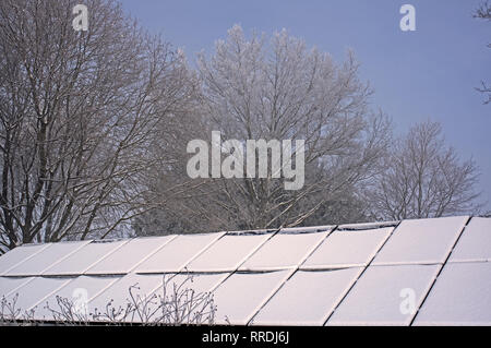 Schnee Solarmodule in Nebel und ein starker Raureif ummantelt. Im frühen Morgenlicht. Stockfoto