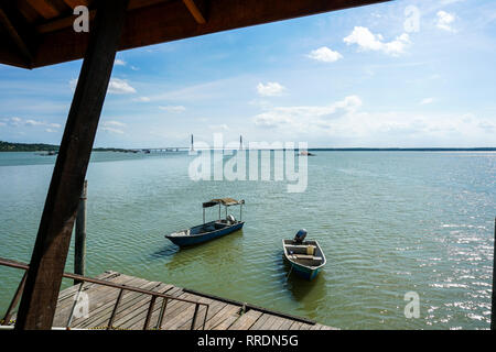 Blick auf Boot von den Holzsteg mit Johor River Bridge im Hintergrund angedockt. Blick von einem Holzsteg Stockfoto