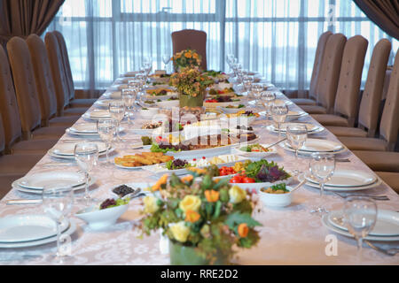 Schön dekorierten Tisch mit leeren weißen Teller, Gläser und Besteck auf luxuriösen Tischdecken Stockfoto