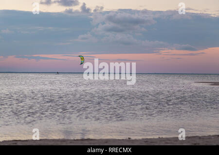 Ein Kite Surfer heraus auf das Meer bei Sonnenuntergang auf der Isla Blanca, QR, Mexiko. Stockfoto