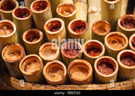 Khao Lam, traditionelle Thai Asiatische süßen Pudding klebrigen Reis Dessert Snack mit gekochten Klebreis und roten Bohnen, Zucker, Kokosraspeln und Kokosnuss mil gemacht Stockfoto