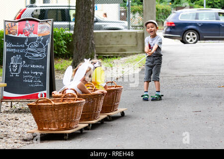 Tunder Fesztival (Feenfest) in Sopron, Ungarn 9. Juni 2018 - Kinder ziehen Körbe mit Rädern und Kinder sitzen in Stockfoto