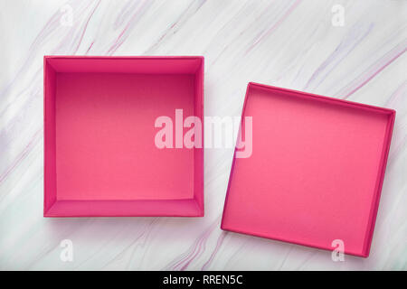 Flach der leeren rosa Geschenk Box mit Deckel auf natürliche Marmor Textur. Rosa Karton mit Cove Stockfoto