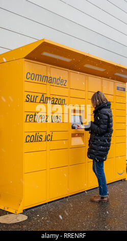 Straßburg, Frankreich - Feb 8, 2018: Seitenansicht des jungen französischen Frau mit Amazon Spind die Self-service-Paketdienst Station in der Nähe von Auchan Supermarkt Stockfoto