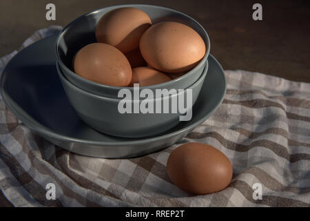 Huhn Eier in einem grauen Schale auf einem karierten Tuch. Stockfoto