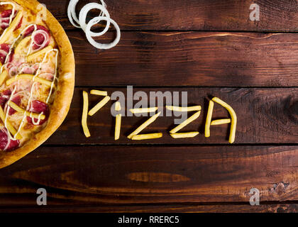 Köstliche italienische Pizza mit Pommes frites auf einem Holztisch Stockfoto