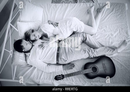 Schwarz-weiß Foto im Retro-stil. junges Ehepaar auf dem Bett liegend Stockfoto
