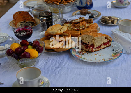 Details einer Tee- tisch. Kaffee Service, Geschirr, Teller, Vasen und gefüllt mit leckeren Torten, Kuchen, Marmelade usw. Summer Tea Party Stockfoto