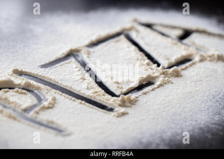 Pizza Wort in Mehl auf schwarz Tabelle geschrieben Stockfoto