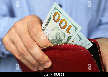 Wallet mit US-Dollar in den männlichen Händen, bar bezahlen oder Shopping Konzept. Menschen haben das Geld aus dem roten Leder Geldbörse, Hand, Dollar Stockfoto