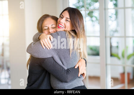 Schöne Familie von Mutter und Tochter zusammen, umarmen und küssen zu Hause Stockfoto