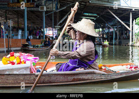 Damnoen Saduak, Thailand - 29. August 2018: Frau verkaufen Girlanden aus ein Boot in Damnoen Saduak Markt, Ratchaburi, Thailand. Stockfoto