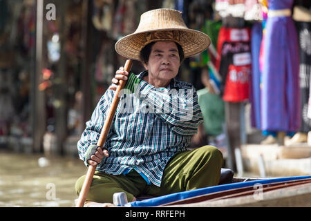 Damnoen Saduak - August 29, 2018: Ältere Frau paddeln ihr Boot in Damnoen Saduak Markt, Ratchaburi, Thailand. Stockfoto
