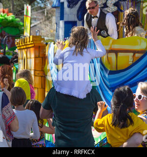 New Orleans, USA. 24. Feb 2019. Festliche und schöner Tag für Mardi Gras Paraden in New Orleans, LA, wie ein Kind sitzt auf den Schultern, die versuchen, Perlen aus dem Float, von ihr geht. Credit: Tom Pumphret/Alamy Live News Credit: Tom Pumphret/Alamy leben Nachrichten Stockfoto