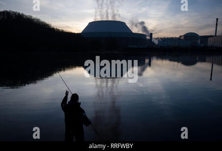 Neckarwestheim, Deutschland. 26 Feb, 2019. Ein Mann angeln am Neckar, der Kühlturm des Kernkraftwerks Neckarwestheim spiegelt sich im Wasser. Credit: Marijan Murat/dpa/Alamy leben Nachrichten Stockfoto