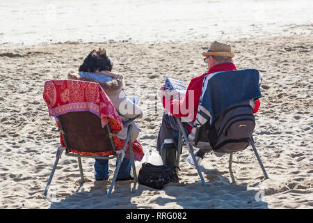 Bournemouth, Dorset, Großbritannien. 26 Feb, 2019. UK Wetter: warmes Wetter fährt mit einem anderen schönen warmen sonnigen Tag in Bournemouth wie Besucher die Sonne am Meer genießen, erwartet der heisseste Tag des Jahres zu sein und den heißesten Februar Tag überhaupt. Bournemouth strand ist der beste Strand in Großbritannien gewählt. Paar Lesen von Zeitungen. Credit: Carolyn Jenkins/Alamy leben Nachrichten Stockfoto