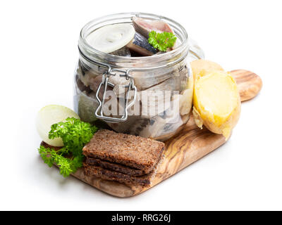 Hausgemachte marinierte Hering in Glas Glas mit Roggenbrot und Jacke Kartoffel in Weiß isoliert Stockfoto