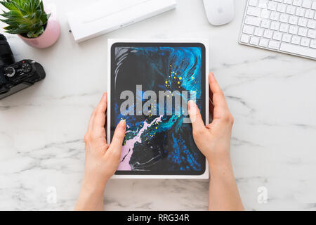 ZAGREB, KROATIEN - 18. FEBRUAR 2019: Frauen Hände halten eine Schachtel pro 11-Zoll Apple iPad von Apple Bleistift 2 Computer- und Kameraanschlüsse auf weiß ma umgeben Stockfoto