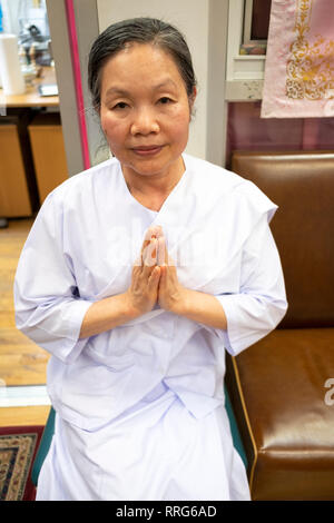 Portrait von einer buddhistischen Nonne in weißer Kleidung zu einem Gebet Service an einem Tempel in Elmhurst, Queens, New York City. Stockfoto