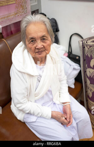 Portrait von einer buddhistischen Nonne in weißer Kleidung zu einem Gebet Service an einem Tempel in Elmhurst, Queens, New York City. Stockfoto