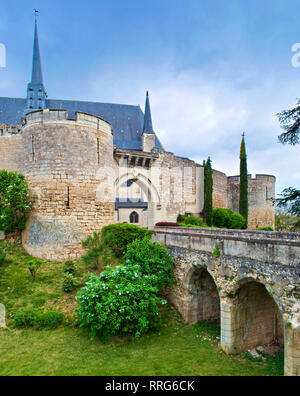 Gewölbten Steinbrücke und Eingang des majestätischen Schloß Montreuil-Bellay Schloss und die umliegenden Wände in Frankreich. Bewölkt Frühling Morgen, grünen Rasen Stockfoto