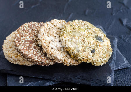 Gesunde Desserts Müsli Snacks. Fitness Ernährung super Essen. Kozinaki mit Sesam, Flachs, Erdnüsse, Sonnenblumenkerne und kürbiskerne am Schiefer Platte. Vegetar Stockfoto