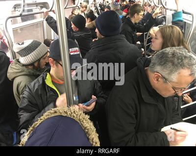 Überfüllte u-bahn Auto voller Menschen, von der Arbeit nach Hause kommen an einem kalten Winter am Nachmittag in New York City. Stockfoto
