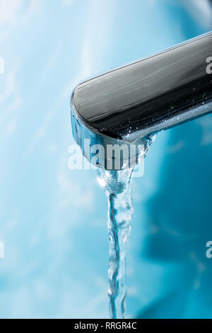 Wasser fließt von einer modernen verchromtem Wasserhahn Wasserhahn Makro Nahaufnahme. Stockfoto