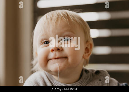 Cute adorable kleine Blonde Kleinkind Kind Lachen, Spaß haben, und die dummen Gesichter außerhalb zu Hause auf der Terrasse Veranda Stockfoto