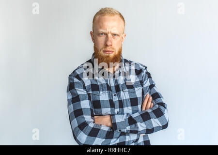 Freestyle. Reifer Mann stehend auf Grau verschränkte Arme suchen Kamera isoliert verwirrt close-up Stockfoto