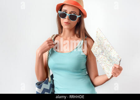 Freestyle. Frau mit Hut stehend Studio auf Weiß mit Strandtasche Lüfter mit Karte Gefühl heiß isoliert Stockfoto