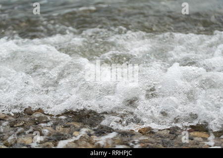 Ein felsiger Strand in Kroatien vor dem Hintergrund des blauen Meer Wasser und Wellen. Nahaufnahme mit einem verschwommenen Hintergrund. Stockfoto