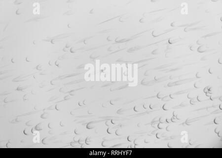 Detail of a white wall with many black traces left by a squash ball. Red floor. Photographed on a public outdoor sports ground Stockfoto