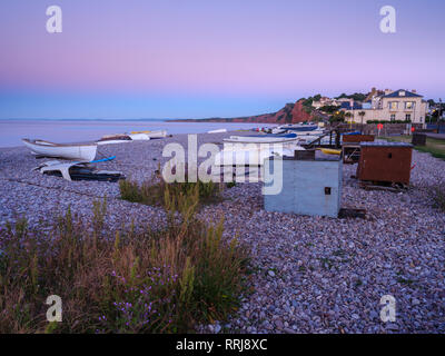 Eine lila Dämmerung mit Booten auf dem Kiesstrand an Budleigh Salterton, Devon, England, Vereinigtes Königreich, Europa Stockfoto