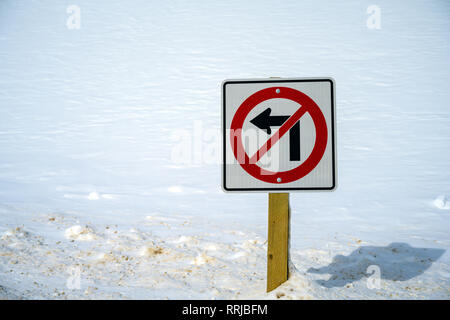 Eine keine links abbiegen Verkehrsschild unter Schnee begraben. Es ist tiefer Schnee alle um ihn herum in Jasper National Park, Alberta, Kanada Stockfoto