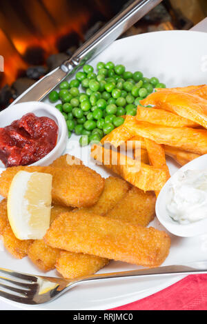 Klassische englische Pub Mittagessen von Fischstäbchen, Pommes und Garten Erbsen serviert mit hausgemachtem Tomatenketchup, Remoulade und frische Zitrone Keil. Stockfoto