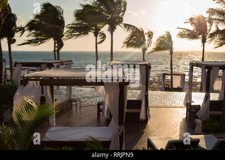 Private Betten in einem Wohnbereich eines High End mexikanisches Resort mit Blick auf das Meer bei Sonnenaufgang. Stockfoto