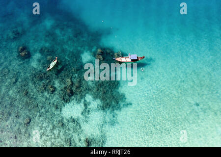 Ansicht von oben, beeindruckende Luftaufnahme von zwei traditionelle Longtail Boote schwimmend auf einem Türkis und klaren Meer. Freedom Beach, Phuket, Thailand Stockfoto