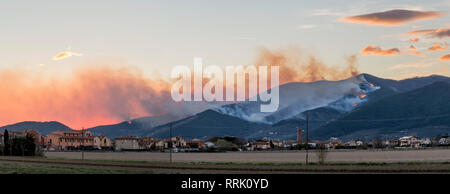 Übersicht des Monte Pisano in Flammen bei Sonnenuntergang von Bientina, Toskana, Italien Stockfoto