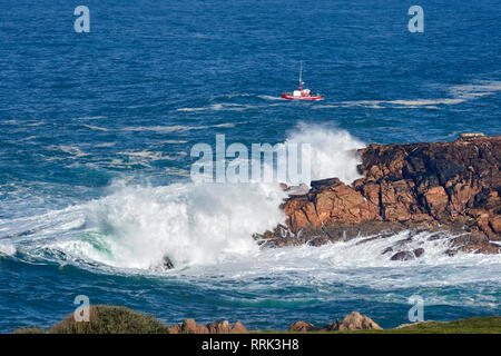 Wellen gegen die Felsen, Fischerboot Stockfoto