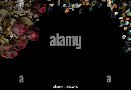 Romantische Hintergrund in sanften Farben des Herbstes mit getrockneten Rosen und pot pourri auf schwarzem Hintergrund Stockfoto