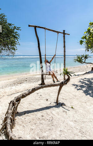 Indonesien, Gili Trawangan Insel junge Frau schwingen auf Swing. Stockfoto