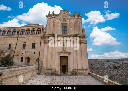 Das Kloster des hl. Agostino sitzt auf einer steilen Klippe mit Blick auf eine tiefe Schlucht Schlucht mit prähistorischen Sassi Höhlen in Matera, Italien gefüllt. Stockfoto