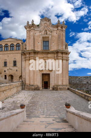 Das Kloster des hl. Agostino sitzt auf einer steilen Klippe mit Blick auf eine tiefe Schlucht Schlucht mit prähistorischen Sassi Höhlen in Matera, Italien gefüllt. Stockfoto