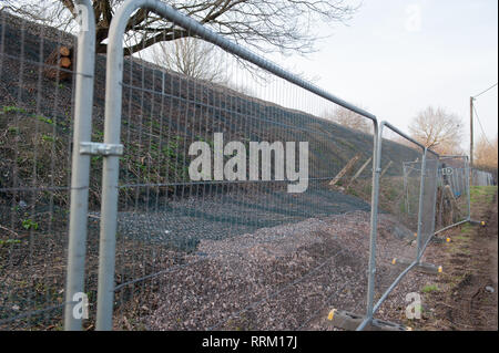 Sicherheitsbarrieren und schützende Verrechnung für Arbeiten am Bahndamm durchgeführt werden. Stockfoto