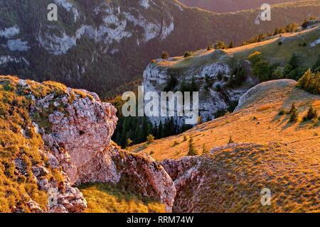 Felsmassiv mit goldenen Gras und Wälder im Licht des Herbstes Sonnenuntergang Stockfoto