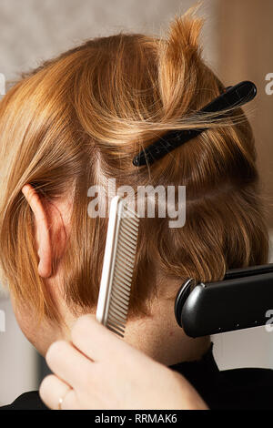 Hairstylist kurzes Haar mit Bügeleisen curl Stockfoto