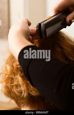 Hairstylist kurzes Haar mit Bügeleisen curl Stockfoto